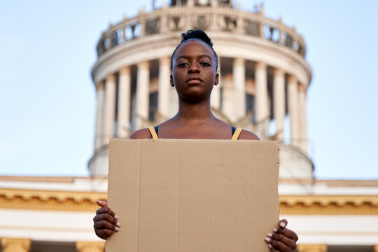 Young african woman activist stand outdoor hold empty blank sign protesting on street. Black female protest against discrimination racism for empowerment, civil rights, racial equality justice concept