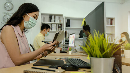 creative people and graphic designer wearing mask to protect covid 19 or coronavirus, check and colect color for create template in office