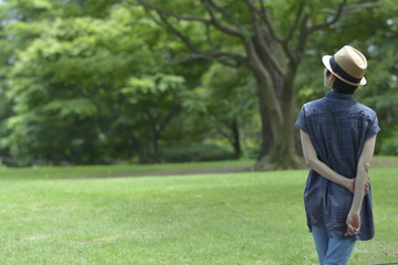 Asian young women.  like spending time in the middle of nature.   wear a hat at a rakish angle.  blurred background with copy space.