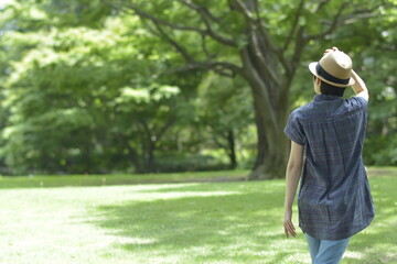 Asian young women.  like spending time in the middle of nature.   wear a hat at a rakish angle.  blurred background with copy space.