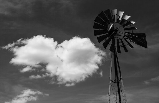 Old windmill in black and white against a cloudy sky