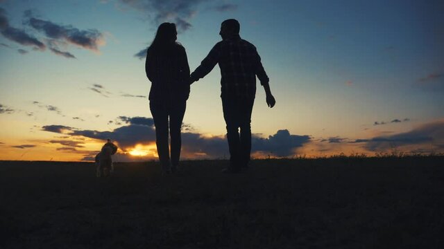 happy family couple and dog runs lifestyle hands at sunset on a hilltop. concept of team business concept travel freedom victory happiness teamwork. happy family parents hold hands run in the rays of