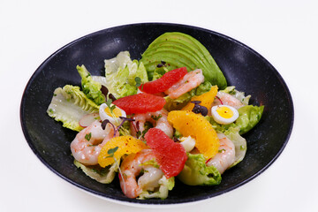 .salad with avocado and shrimps in bowl, top view, copy space, black background