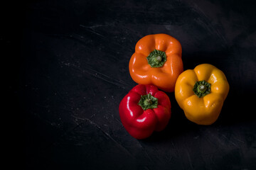  bell peppers on black background