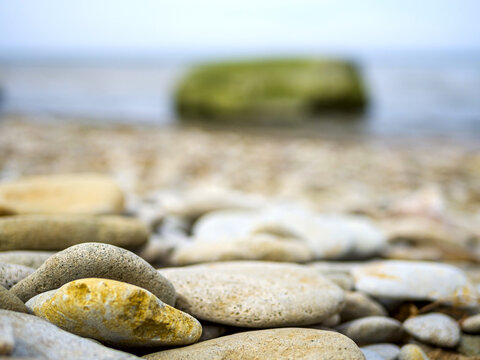 Selective focus. Coast. Spa stones, sea beach. Coast. many Stones on the beach and sea water in sunset light. 