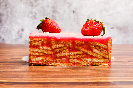 A picture of "batik" with strawberry on top. It is frozen cake made with egg, butter, biscuits, milk, chocolate powder and strawberry flavour.         