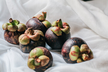 Delicious fresh mangosteen and cross section showing the thick purple skin and white flesh of the...