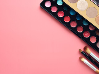 Makeup kit and cosmetic set on pink surface. 