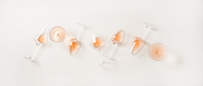 Rose wine variety layout. Flat-lay of rose wine in various glasses over plain white background, top view. Summer drink for party, wine shop or wine tasting concept