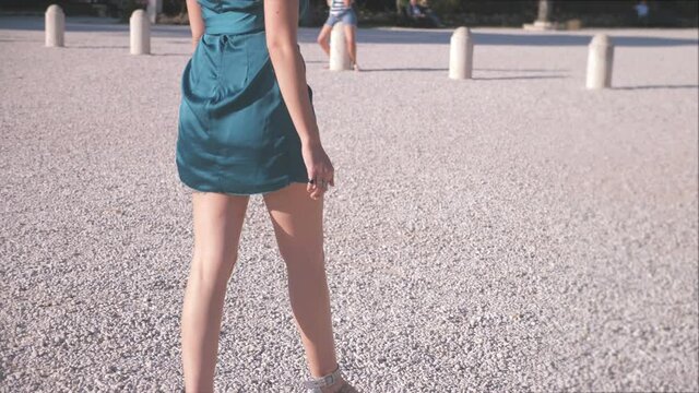 back view of attractive woman wearing low-cut mini dress walking