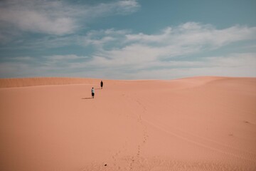 Fototapeta na wymiar Two people in the Wahiba Desert Oman