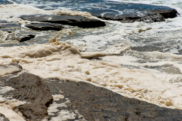 Ocean storm aftermath: A mass of thick foam covered the rocks following extreme storm weather at Cronulla, NSW, Australia.