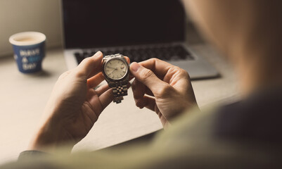 fashionable wearing stylish looking at luxury watch on hand check the time at workplace.concept for managing time organization working,punctuality,appointment