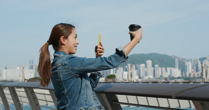 Woman take photo on her cup of coffee in city