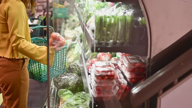 スーパーマーケットで野菜を買う女性