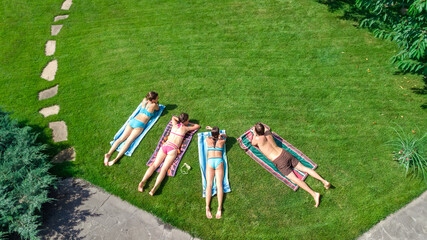 Happy family relaxing by swimming pool, aerial drone view from above of parents and kids have fun...
