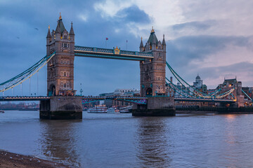 Fototapeta na wymiar View of the London city skyline at sunset on a cloudy day with Tower Bridge on Thames river in England, United Kingdom