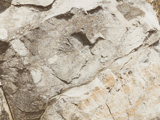 Natural background. Closeup edged shabby cliff cracks. Gray-brown stone rock texture of mountains. Vintage and faded matt style colour in tinted photo. Concept of geolog, mountaineering or hard work