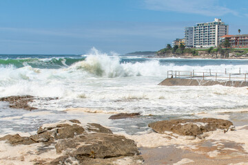 Ocean storm aftermath: A mass of thick foam covered the rocks near rock pool following extreme storm weather at Cronulla, NSW, Australia