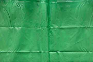 crumpled green plastic cover texture with creases. abstract background