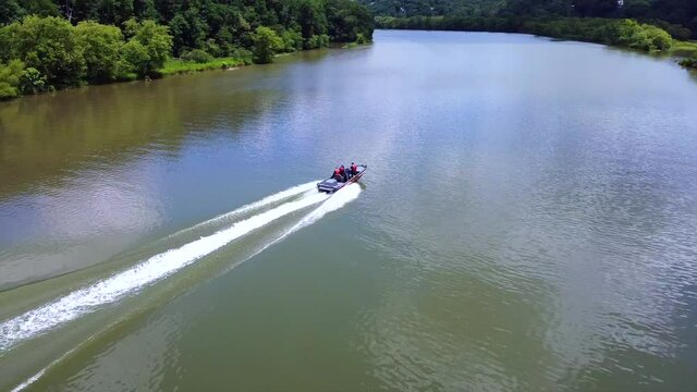 In this flyover we capture a aerial video following a boat on the lake. The aerial video pans from right to left as we slowly ascend all the while keeping the boat in view.