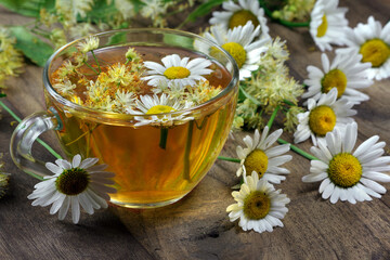 Obraz na płótnie Canvas summer herbal tea. linden and chamomile tea on a wooden table. 