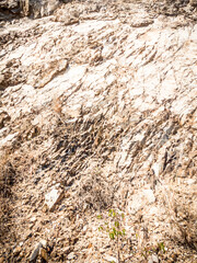 Natural background. Closeup edged shabby cliff cracks. Gray-brown stone rock texture of mountains. Vintage and faded matt style colour in tinted photo. Concept of geolog, mountaineering or hard work