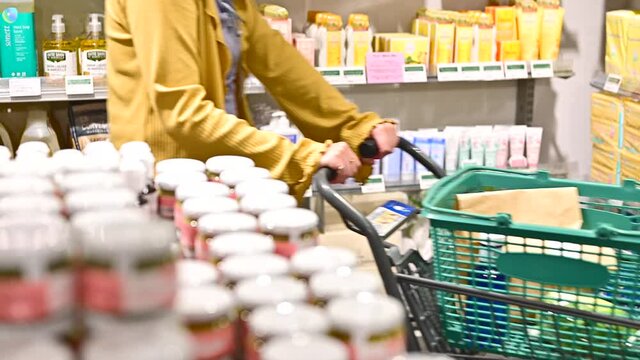スーパーマーケットで日用品の買い物をする女性