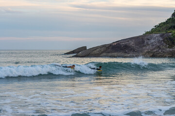 Fototapeta premium Garotos fazendo manobras radicais com suas pranchas de bodyboard na praia