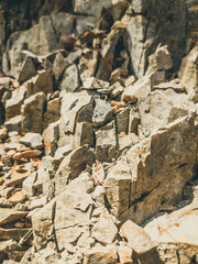 Natural background. Closeup edged shabby cliff cracks. Gray-brown stone rock texture of mountains. Vintage and faded matt style colour in tinted photo. Concept of geolog, mountaineering or hard work