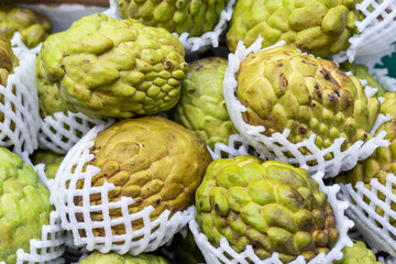 Barraca em mercado com diversas frutas em exposição incluindo laranja, ameixa, mexerica, fruta do conde.