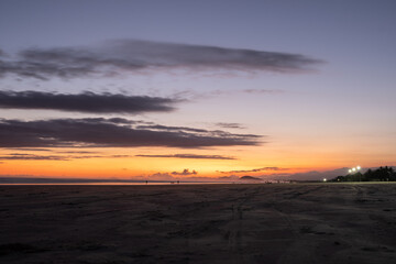 Por do sol na praia mostrando cores e detalhes do ceu 