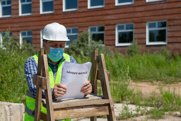 Worker reads the layoff notice outdoor. Unemployment concept. Coronavirus aftermath.