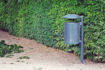 Fototapeta na wymiar public iron trash bin at the park