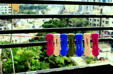 Clothespins of different colours on the wire close-up. Close up colorful clamp-on cloth line on blur background. bokeh background abstract wallpaper