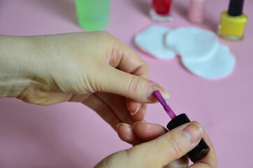 Close up image of woman using nail buffer when doing manicure, polishing nails at home. Smiling...