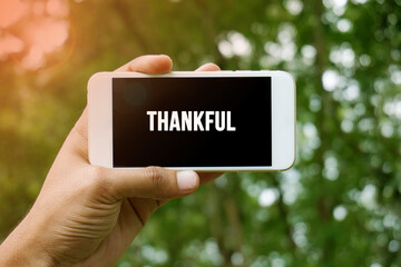 THANKFUL word on smartphone with bokeh in background
