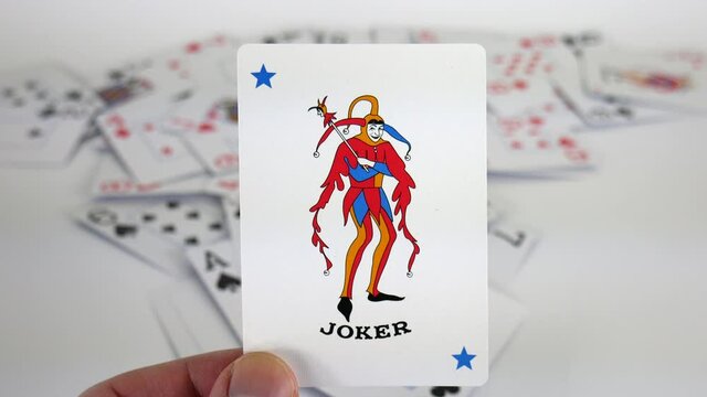 Joker playing card in hand, casino cards, gamble, gambling, poker, game, blackjack, deck, luck, spade, win, winner, chance, jackpot