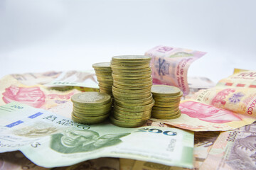 Ten pesos coins on bills of different denominations of Mexican pesos