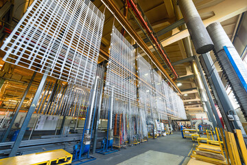 Metal parts are suspended on an overhead conveyor. Line painting in an electrostatic field