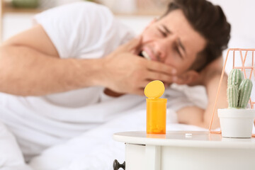 Fototapeta na wymiar Sleeping pills on table in bedroom of young man