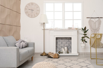 Stylish fireplace with sofa in interior of living room