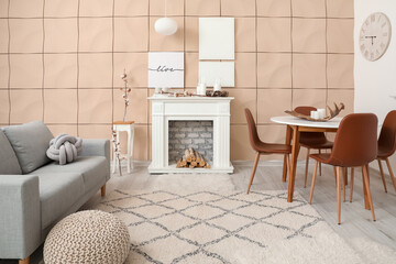 Stylish fireplace with table and sofa in interior of living room