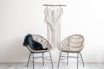 Stylish armchairs near light wall