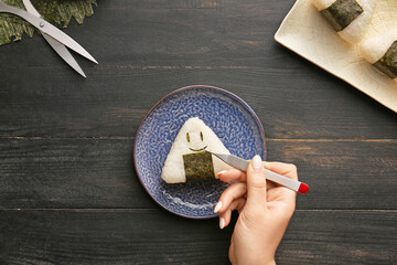 Woman preparing traditional Japanese onigiri on table © Pixel-Shot
