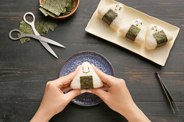 Woman preparing traditional Japanese onigiri on table © Pixel-Shot
