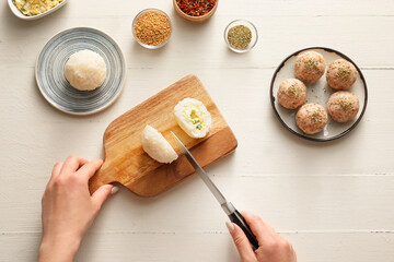 Woman preparing traditional Japanese onigiri on table