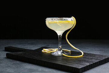 Glass of tasty martini cocktail on dark background