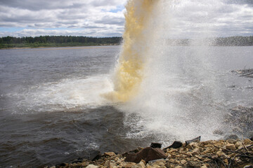 Spillway into the river from an industrial complex. Photo on the topic of ecology.