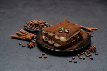 Classic tiramisu dessert on ceramic plate on concrete background